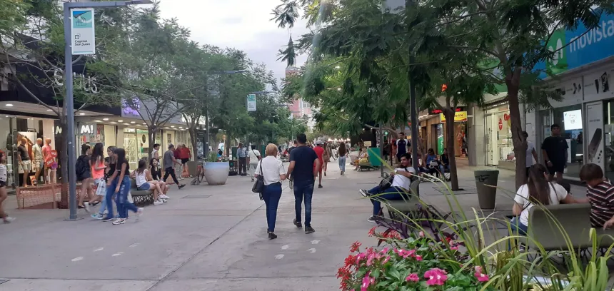 Personas caminan por una calle peatonal arbolada de Rivadavia, San Juan.
