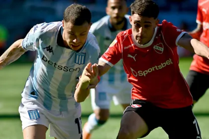 Futbolistas de Racing e Independiente disputan la pelota en la cancha.