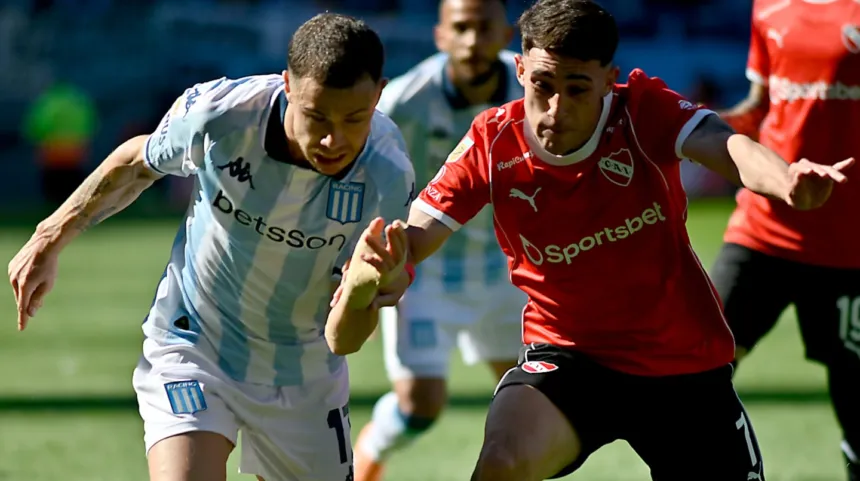 Futbolistas de Racing e Independiente disputan la pelota en la cancha.