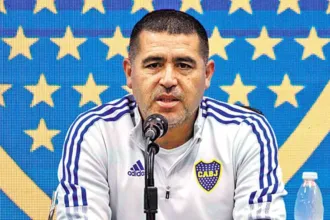 Juan Román Riquelme habla ante un micrófono con indumentaria de Boca.