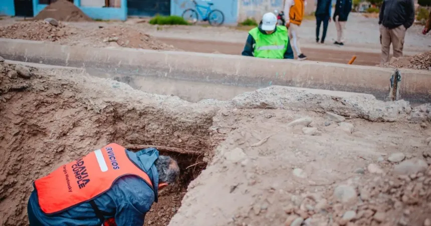 Trabajadores limpian un desagüe en una calle de Rivadavia.