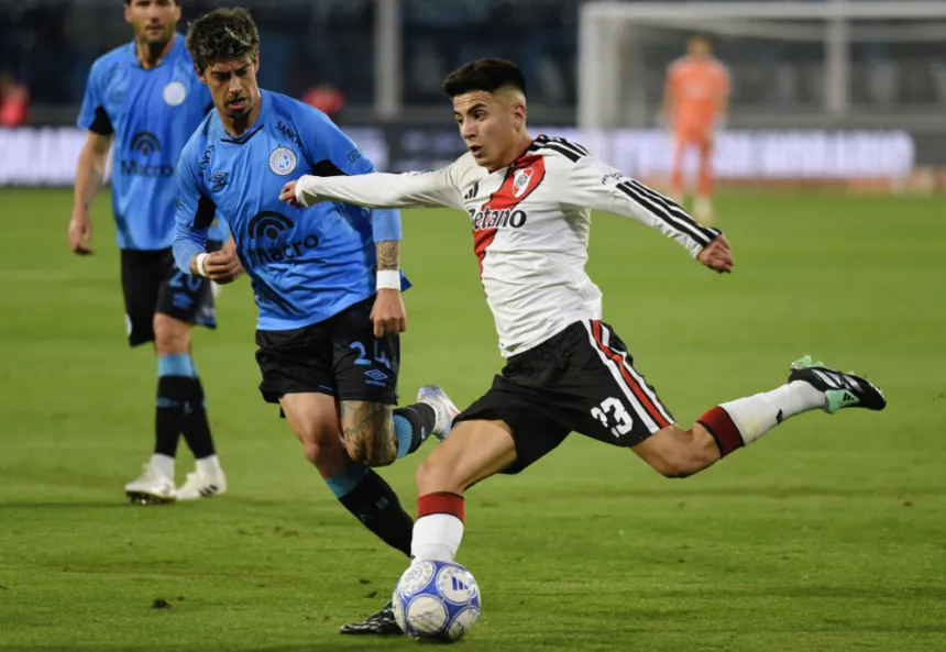 Un jugador de River disputa la pelota con un futbolista de Belgrano.