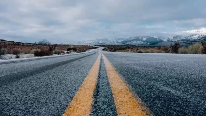 Ruta asfaltada entre montañas nevadas.