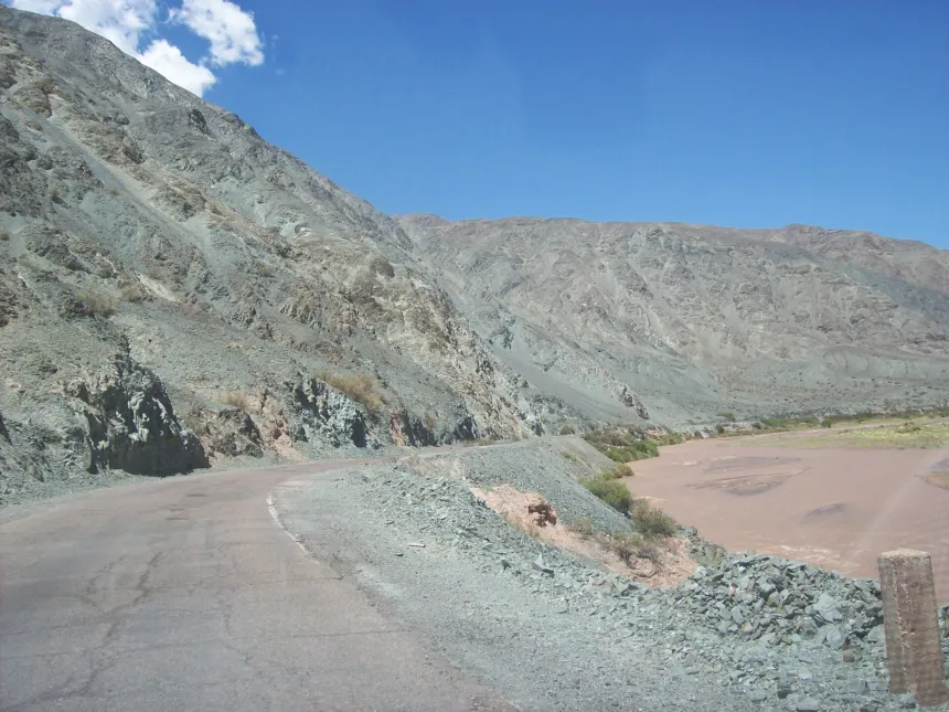 Ruta junto al río San Juan y montañas áridas, bajo un cielo despejado.