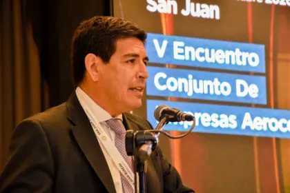Un hombre habla ante un micrófono durante un encuentro de empresas aerocomerciales en San Juan.
