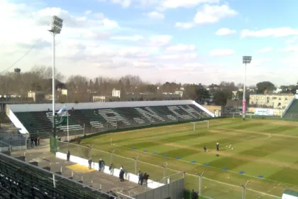 Cancha de Nueva Chicago, con tribunas verdes y negras y el campo de juego.