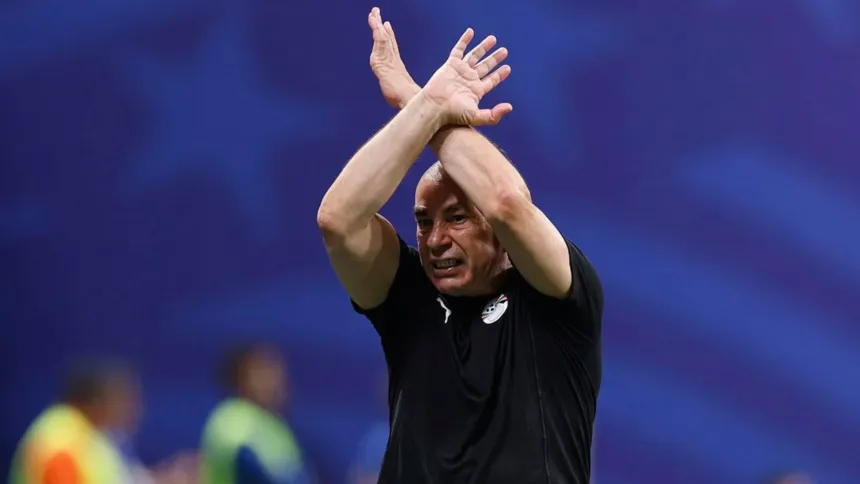 El entrenador de Egipto aplaude con la camiseta de la selección en un estadio.