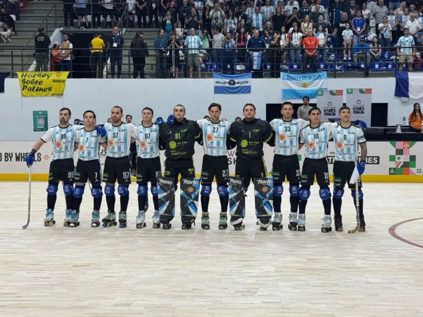 La Selección argentina de hockey sobre patines posa en la cancha con sus uniformes.