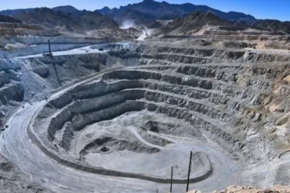 Una mina a cielo abierto se extiende entre montañas.