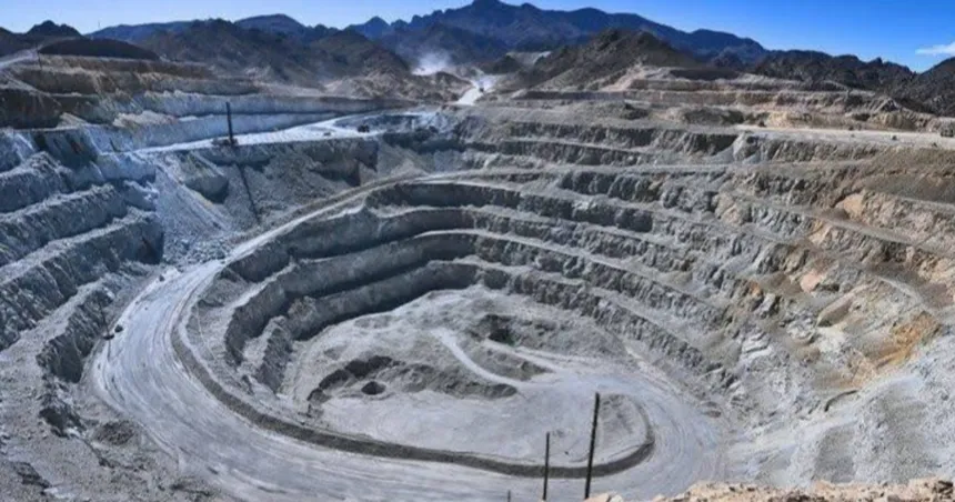Una mina a cielo abierto se extiende entre montañas.