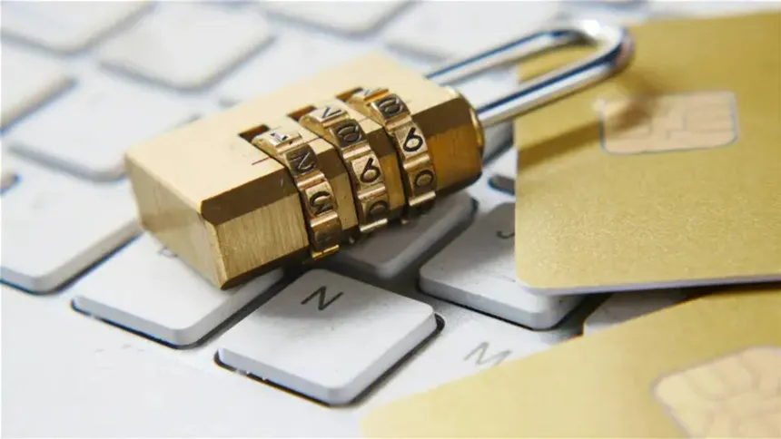 Candado sobre un teclado junto a tarjetas bancarias, en una imagen sobre seguridad digital.
