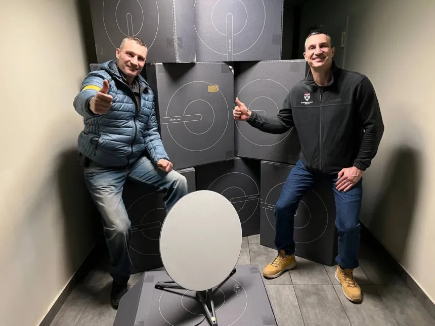 Dos hombres junto a cajas de Starlink y una antena parabólica.