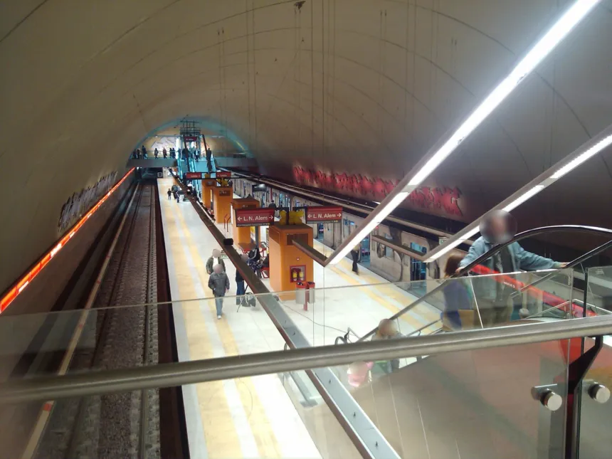 Vista elevada de un andén de subte con pasajeros y carteles hacia L. N. Alem.