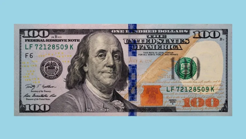 Billete de 100 dólares estadounidenses sobre un fondo celeste.