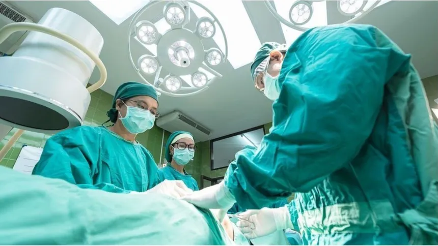 Equipo médico trabaja en un quirófano junto a un paciente cubierto