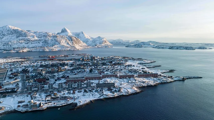 Localidad costera de Groenlandia entre montañas nevadas y el mar.