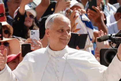El papa León XIV saluda a una multitud entre celulares y cámaras.