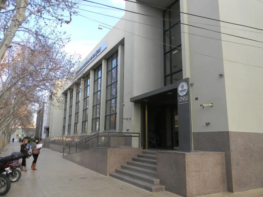 Fachada de un edificio de la UNSJ con su cartel institucional en la entrada.