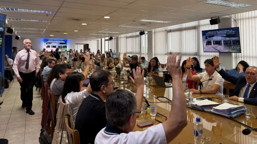 Integrantes del Consejo Superior de la UNSJ levantan la mano durante una votación.