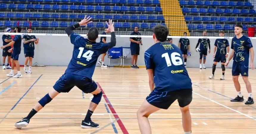 Jugadores de UPCN practican vóleibol en una cancha cubierta.