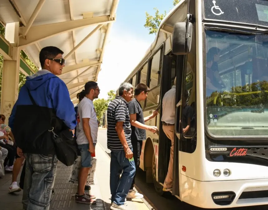 Pasajeros suben a un colectivo de RedTulum en una parada techada.