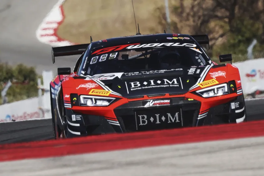Un Audi R8 rojo y negro toma una curva en un circuito.