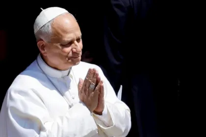El Papa, vestido de blanco, junta las manos en señal de oración.