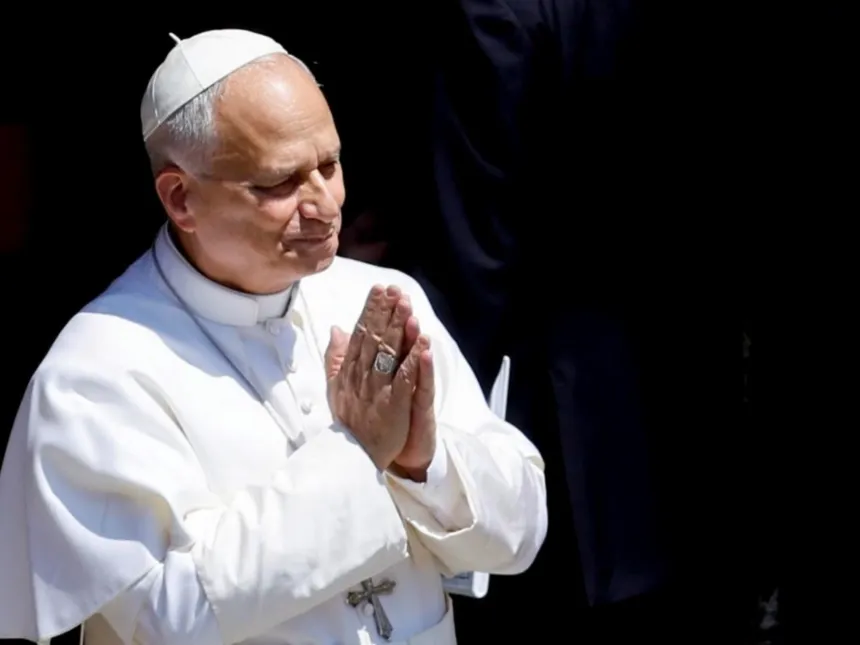 El Papa, vestido de blanco, junta las manos en señal de oración.