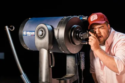 Un hombre mira por un telescopio durante una actividad de observación astronómica.