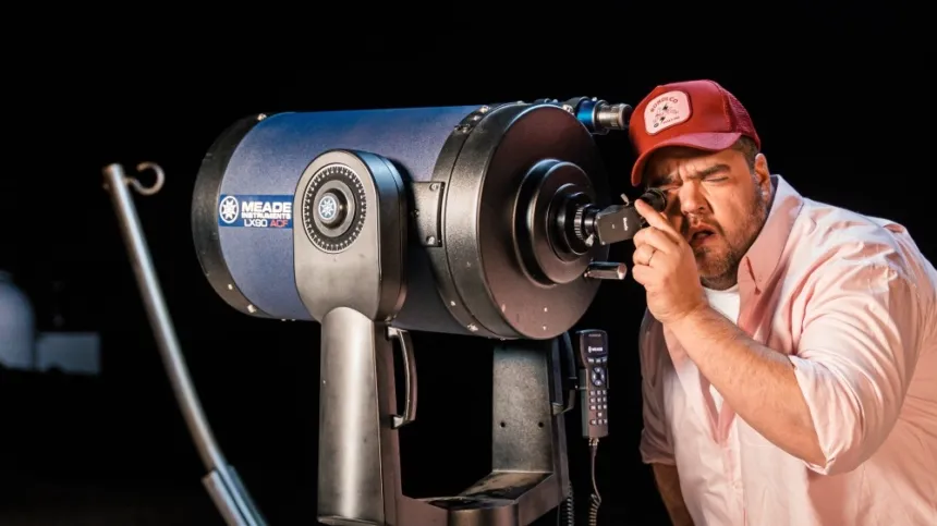Un hombre mira por un telescopio durante una actividad de observación astronómica.