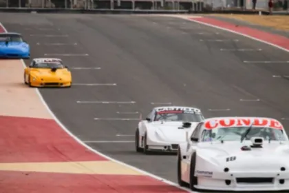Autos de carrera circulan por la pista de un circuito.